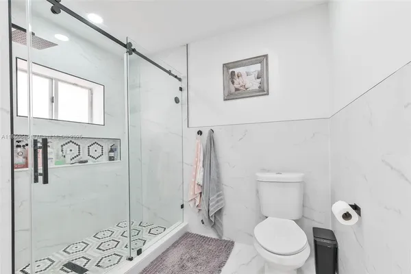 a white toilet sitting next to a bathroom sink