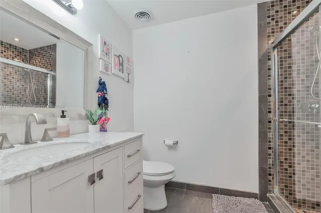 a bathroom with a granite countertop sink toilet and shower