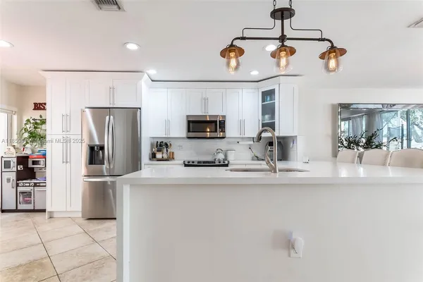 a kitchen with stainless steel appliances granite countertop a refrigerator and a stove top oven