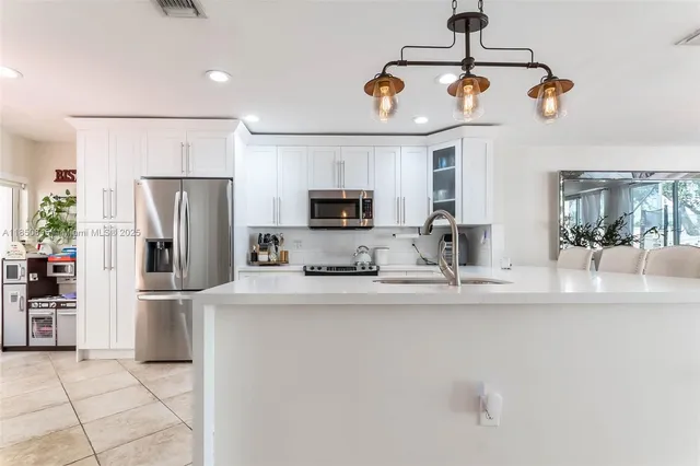 a kitchen with stainless steel appliances granite countertop a refrigerator and a stove top oven