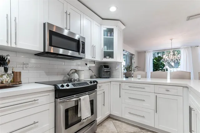 a kitchen with white cabinets stainless steel appliances and a sink