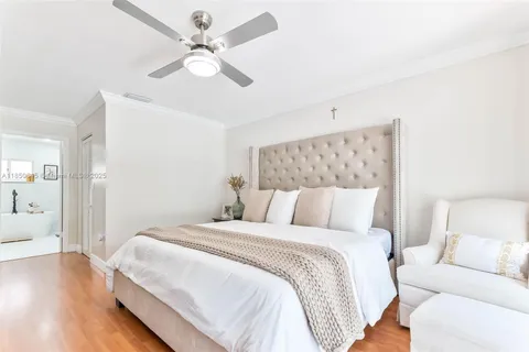 a bedroom with a large bed and a ceiling fan