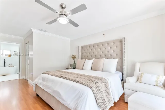 a bedroom with a large bed and a ceiling fan