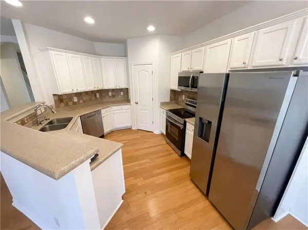 a kitchen with stainless steel appliances a refrigerator stove and sink