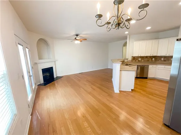 an empty room with windows and ceiling fan