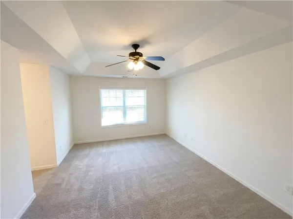 a view of an empty room and a ceiling fan window
