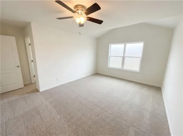 an empty room with a window and a ceiling fan