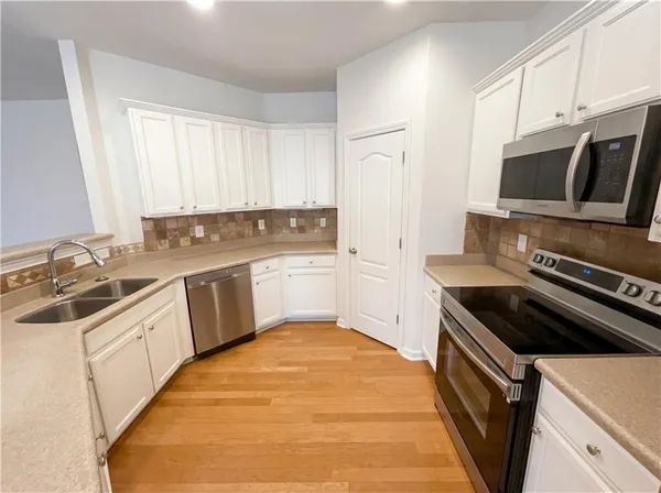 a kitchen with a sink stove top oven and cabinets