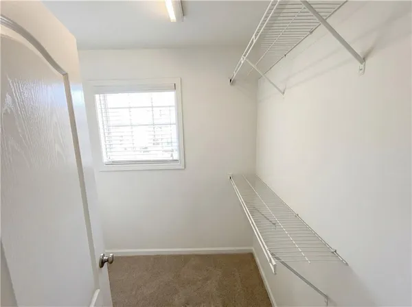 a view of walk in closet with empty racks