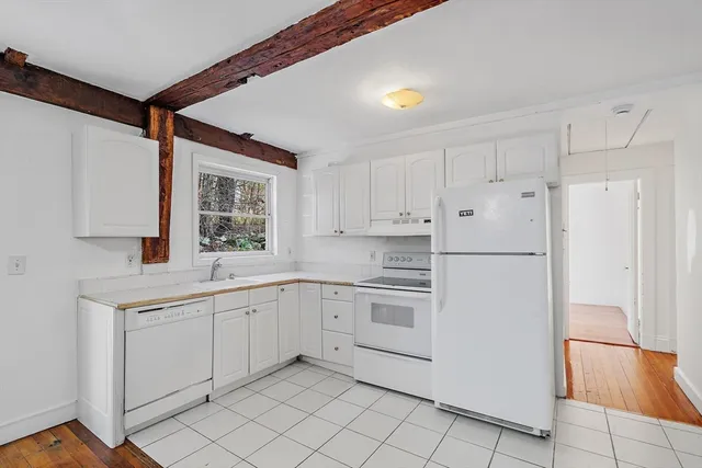 a kitchen with white cabinets and white appliances