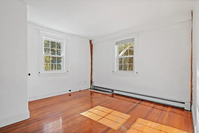 a view of a room with wooden floor and windows