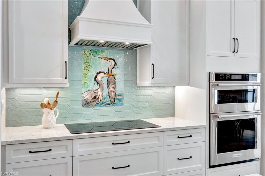 144 Wilderness Cay Naples, FL 34114 - Photo 11 of 42 a kitchen with granite countertop white cabinets and white appliances