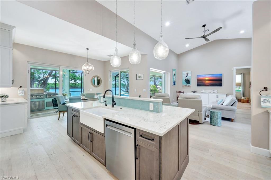 144 Wilderness Cay Naples, FL 34114 - Photo 14 of 42 a view of kitchen island a sink a counter space and living room view