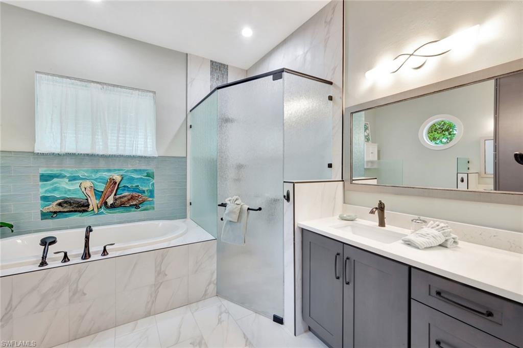 144 Wilderness Cay Naples, FL 34114 - Photo 19 of 42 a bathroom with a double vanity sink mirror and bathtub