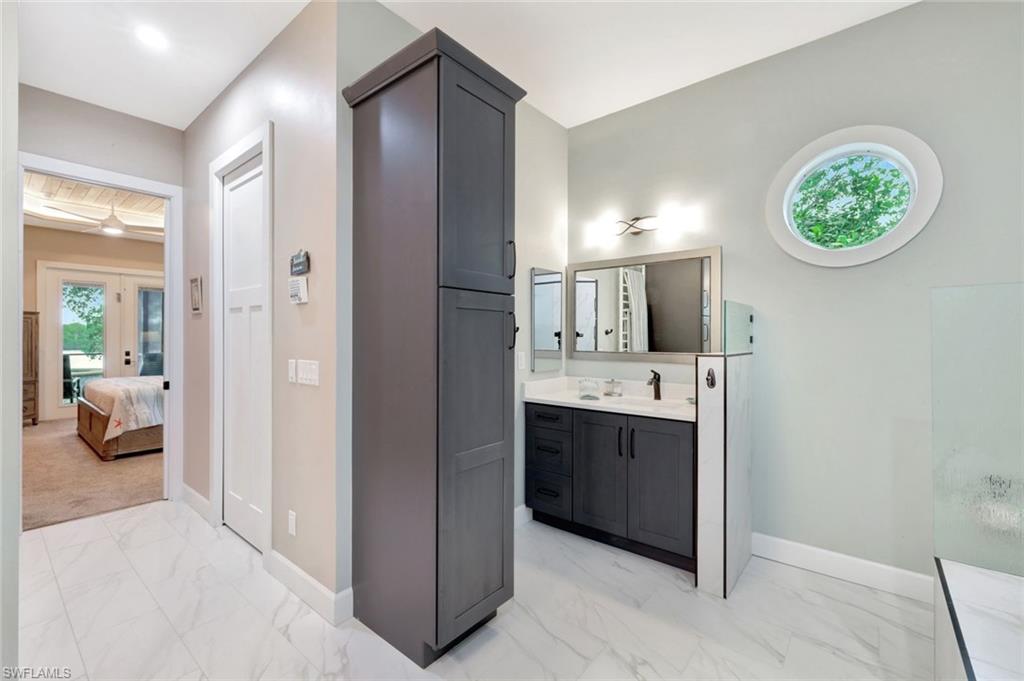 144 Wilderness Cay Naples, FL 34114 - Photo 20 of 42 a en suite bathroom with a sink and a mirror
