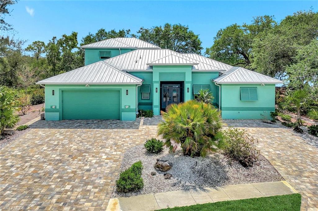 144 Wilderness Cay Naples, FL 34114 - Photo 2 of 42 a front view of a house with garden