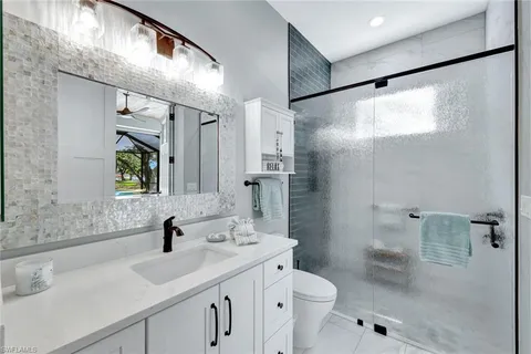 a bathroom with a sink toilet double vanity and shower