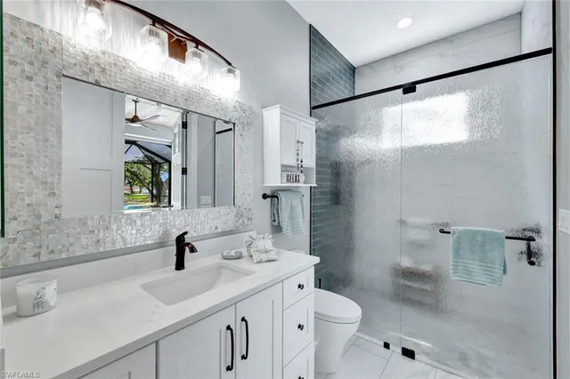 a bathroom with a sink toilet double vanity and shower