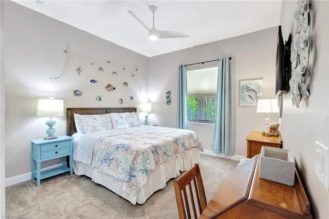 a bedroom with a bed and a flat tv screen on dresser