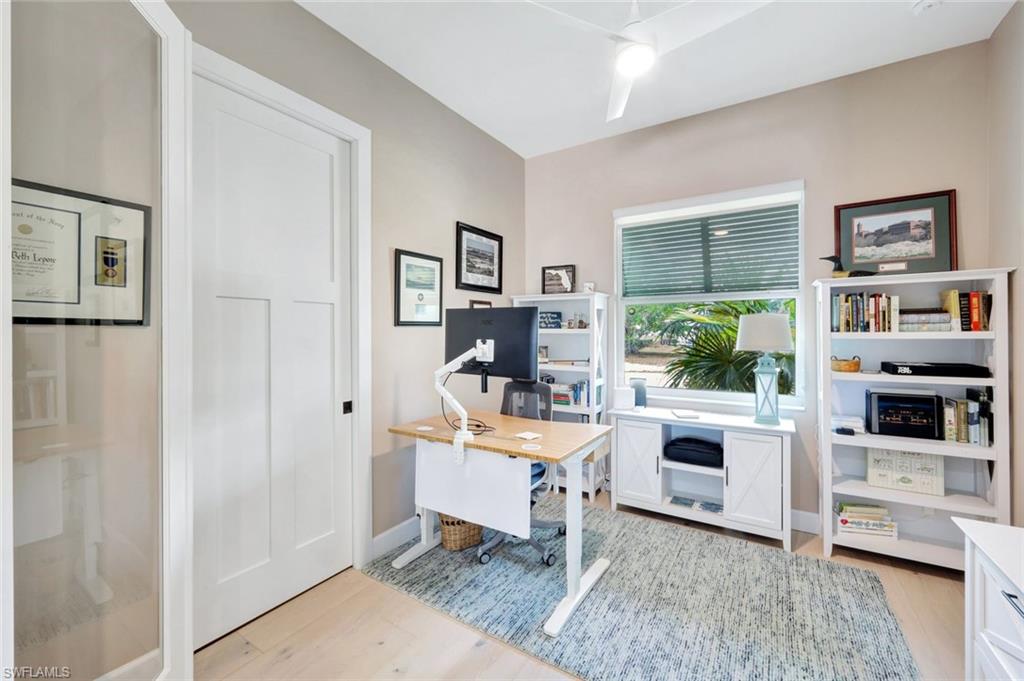 144 Wilderness Cay Naples, FL 34114 - Photo 27 of 42 a living room with furniture a flat screen tv and a fireplace