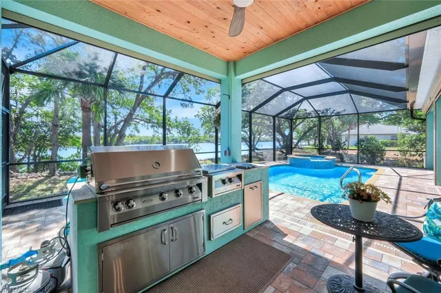 a kitchen with stainless steel appliances kitchen island a table and chairs in it