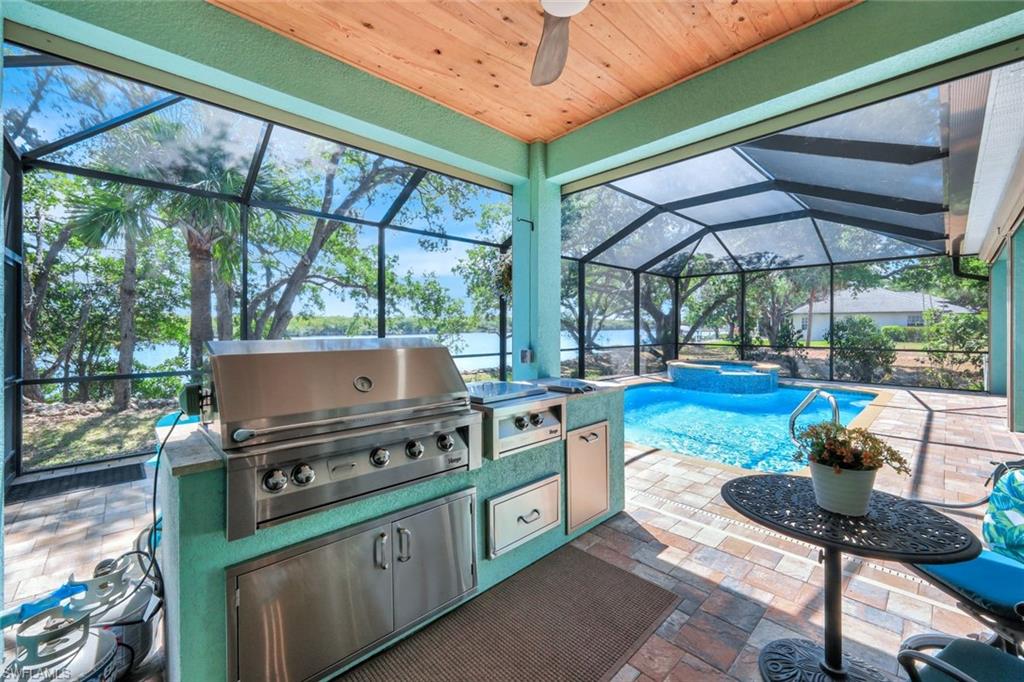 144 Wilderness Cay Naples, FL 34114 - Photo 31 of 42 a kitchen with stainless steel appliances kitchen island a table and chairs in it