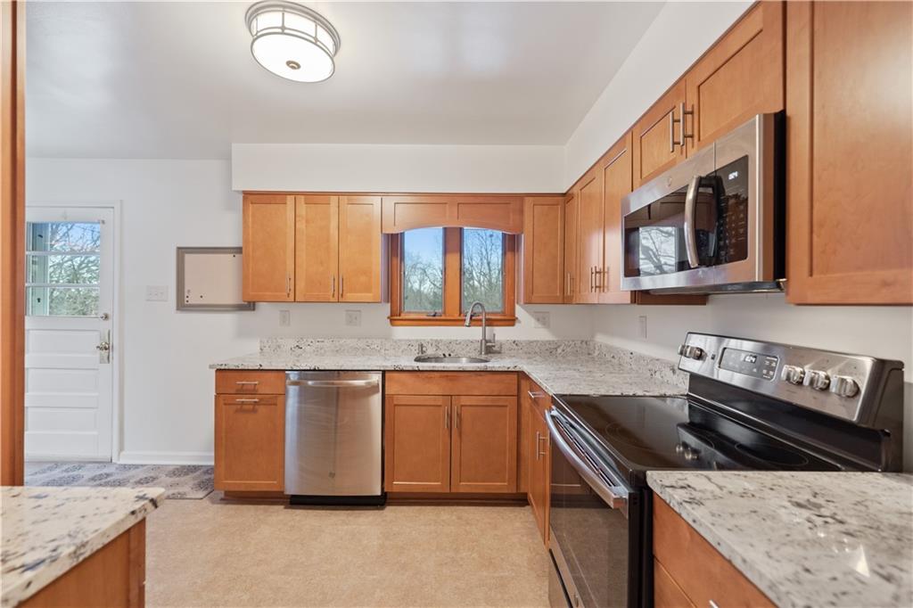 903 Wible Run Road Pittsburgh, PA 15209 - Photo 11 of 33 a kitchen with stainless steel appliances granite countertop a stove a sink and a microwave