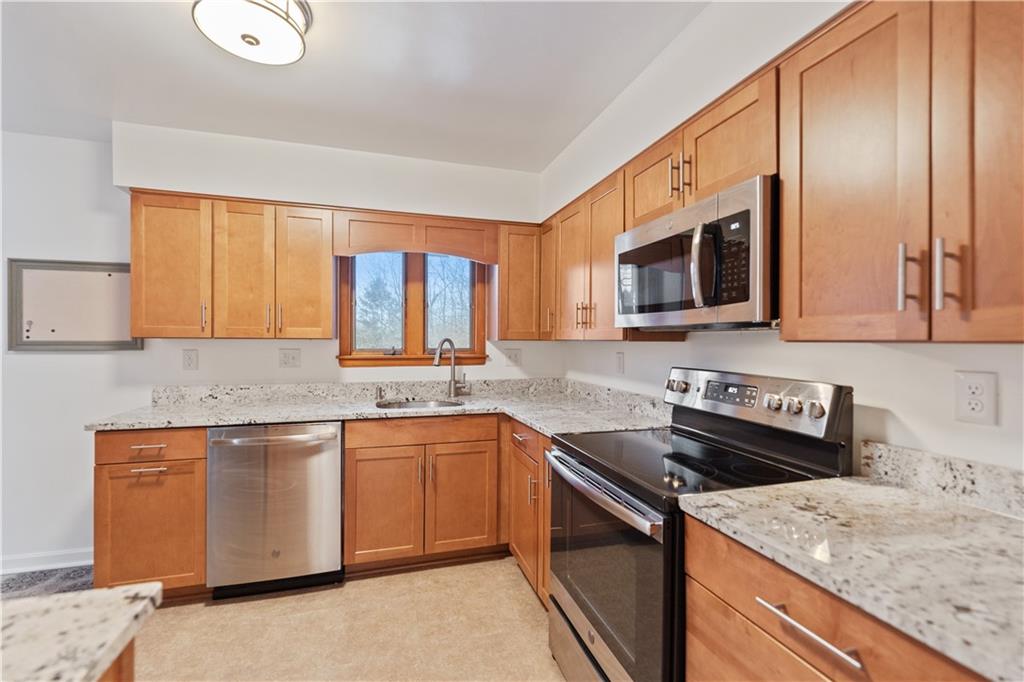 903 Wible Run Road Pittsburgh, PA 15209 - Photo 12 of 33 a kitchen with stainless steel appliances granite countertop a sink stove and microwave