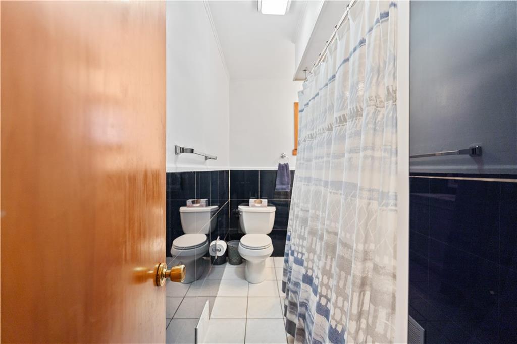 903 Wible Run Road Pittsburgh, PA 15209 - Photo 19 of 33 a bathroom with a toilet and a shower curtain