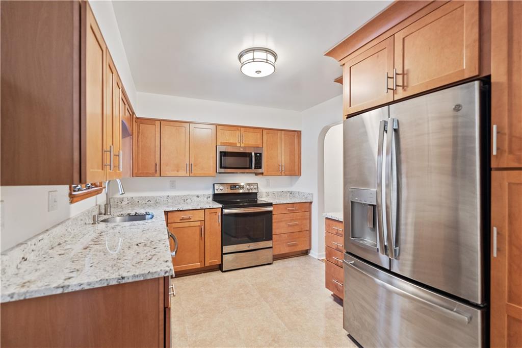 903 Wible Run Road Pittsburgh, PA 15209 - Photo 9 of 33 a kitchen with stainless steel appliances granite countertop a refrigerator stove and sink