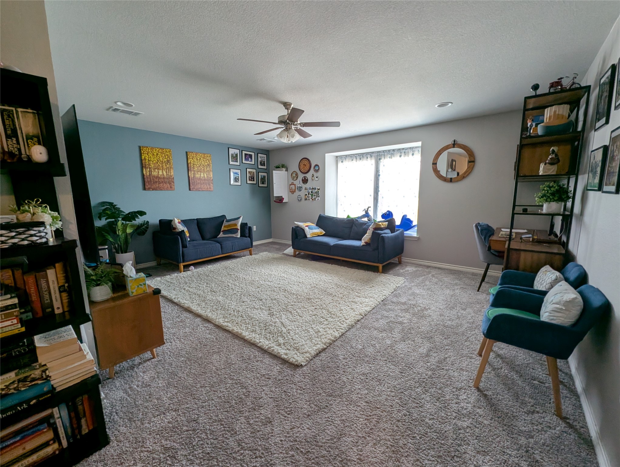 14502 McCoy Loop Austin, TX 78717 - Photo 4 of 26 Expansive carpeted living area featuring a large window, ceiling fan, recessed lighting, and a built-in window seat