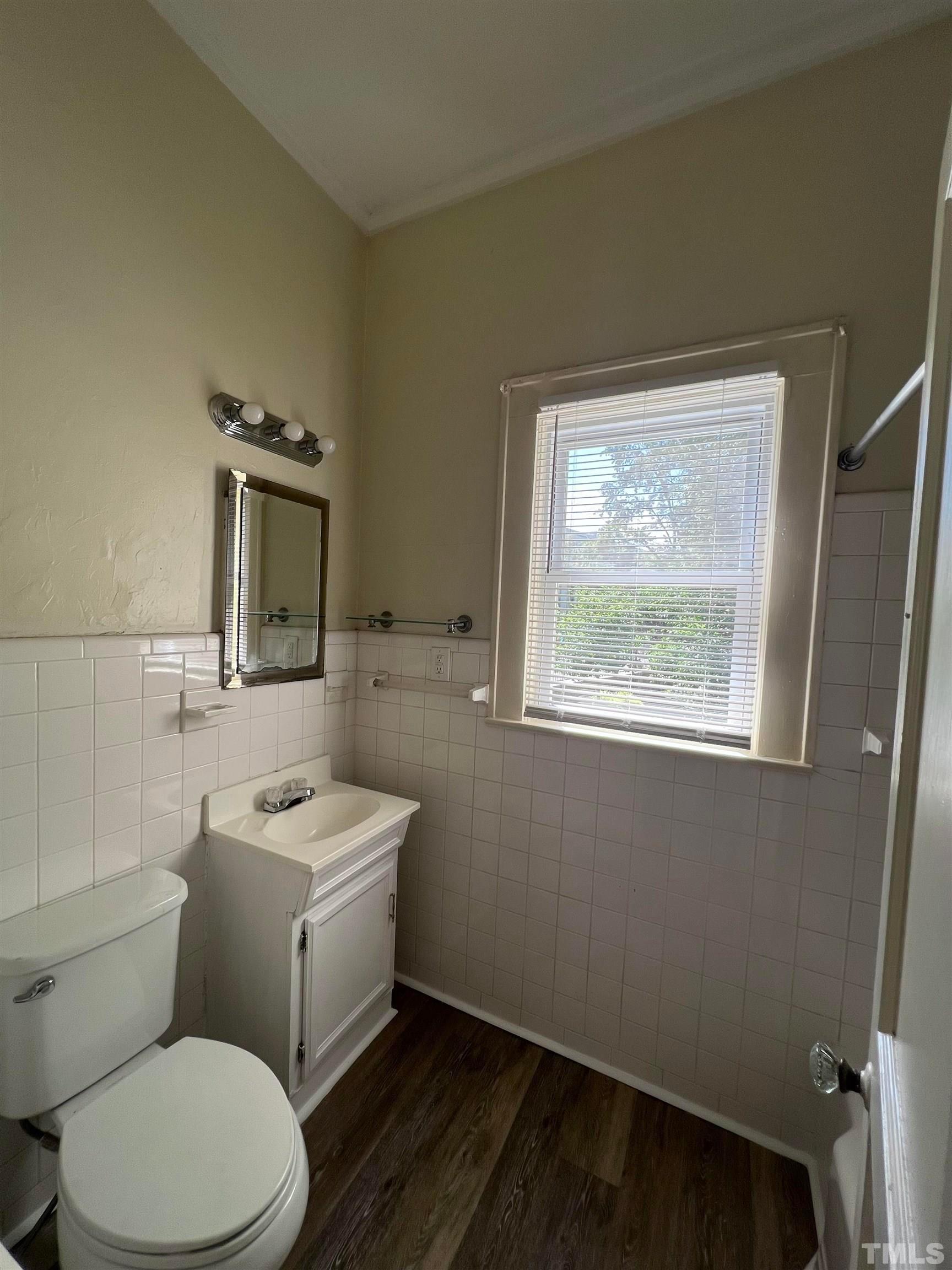 9 Dixie Trail Raleigh, NC 27607 - Photo 12 of 14 a bathroom with a toilet a sink a window and mirror