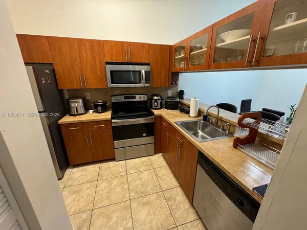 a kitchen with stainless steel appliances a sink dishwasher stove refrigerator and microwave