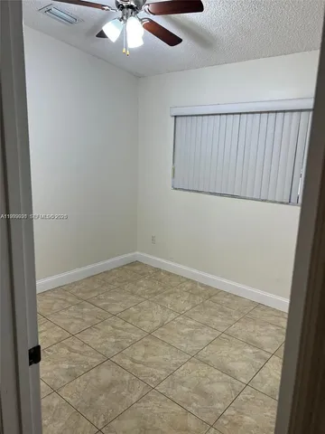 an empty room with a ceiling fan and a ceiling fan