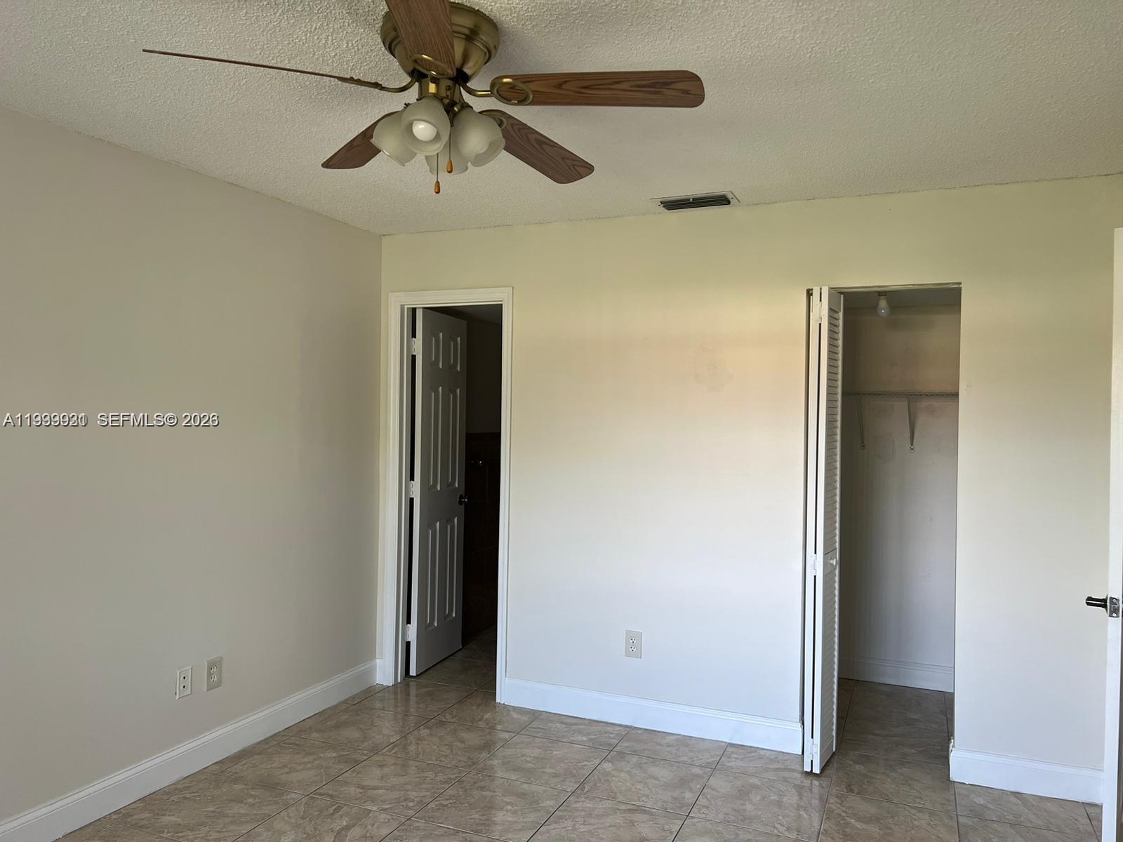 18210 Mediterranean Boulevard, Unit 620 Hialeah, FL 33015 - Photo 7 of 27 an empty room with a ceiling fan and a ceiling fan