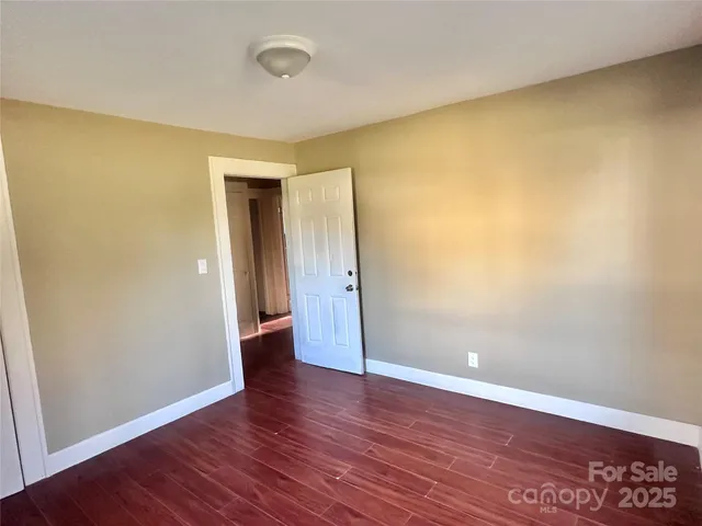 an empty room with wooden floor and closet