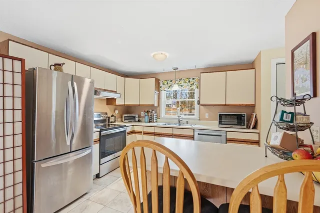 a kitchen with stainless steel appliances granite countertop a refrigerator a stove top oven a sink dishwasher and white cabinets