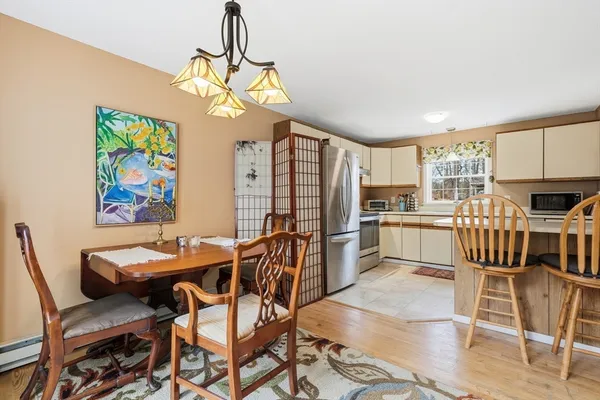 a view of a dining room with furniture a kitchen and chandelier