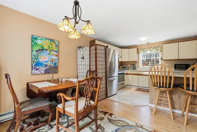 a view of a dining room with furniture a kitchen and chandelier