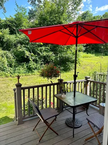 a view of a balcony with chairs and wooden floor