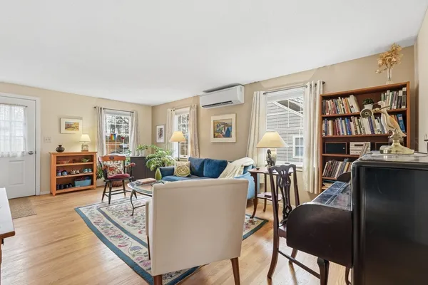 a living room with furniture a large window and wooden floor