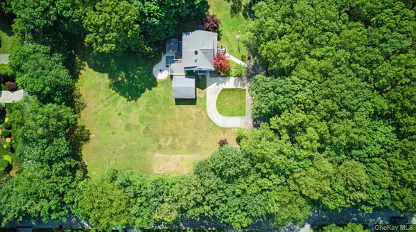 an aerial view of a house with swimming pool a yard and a fountain