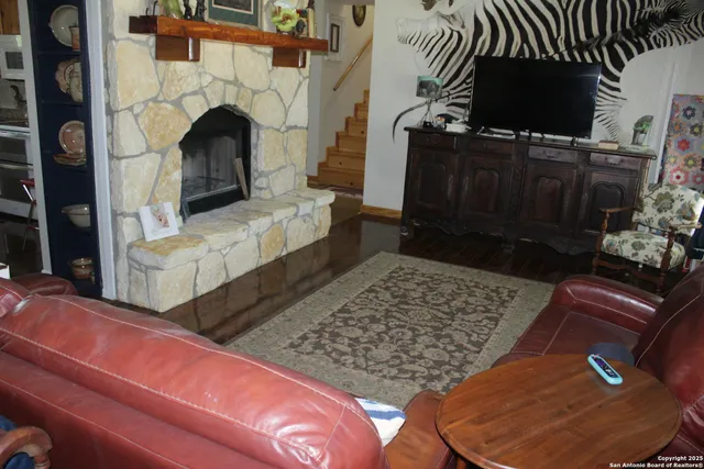a living room with furniture a flat screen tv and a fireplace