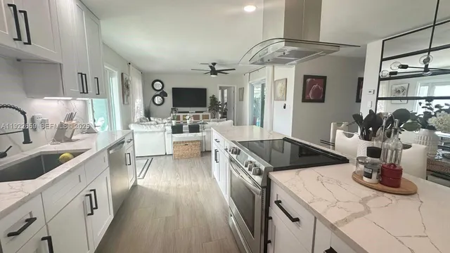 a large kitchen with stainless steel appliances granite countertop a lot of counter space and wooden floors