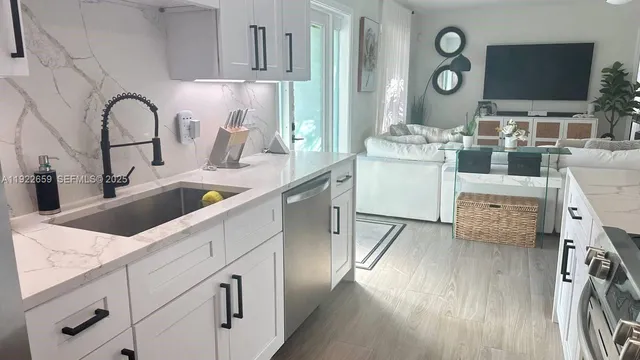 a kitchen with a sink cabinets and wooden floor