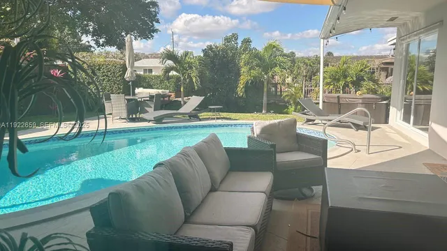 a view of a patio with couches chairs and a floor to ceiling window