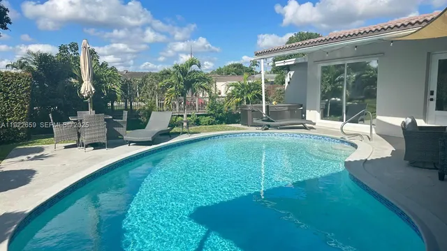 a swimming pool with outdoor seating and yard