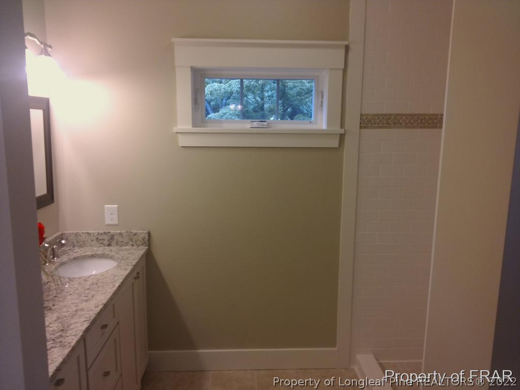 4015 Youngs Road Southern Pines, NC 28387 - Photo 16 of 25 a bathroom with a granite countertop sink and a mirror