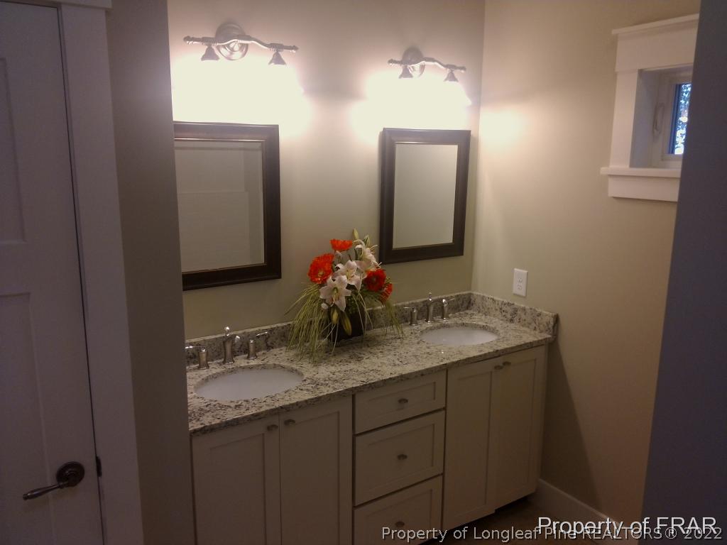 4015 Youngs Road Southern Pines, NC 28387 - Photo 17 of 25 a bathroom with a granite countertop sink and a mirror