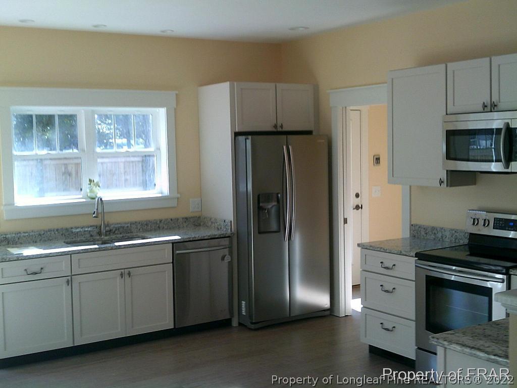 4015 Youngs Road Southern Pines, NC 28387 - Photo 3 of 25 a kitchen with stainless steel appliances granite countertop a refrigerator sink and stove